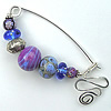 fibula pin, featuring contemporary lampwork beads, fabricated by Robin Atkins, bead artist